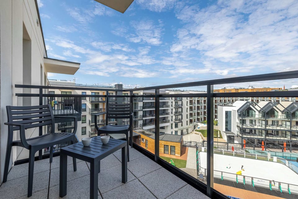 A balcony overlooking the city, equipped with sturdy metal railings and a set of balcony furniture, is a perfect spot for morning coffee.