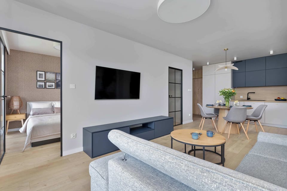 Another perspective of the open-plan lounge area with a TV, large windows, and sleek modern design.