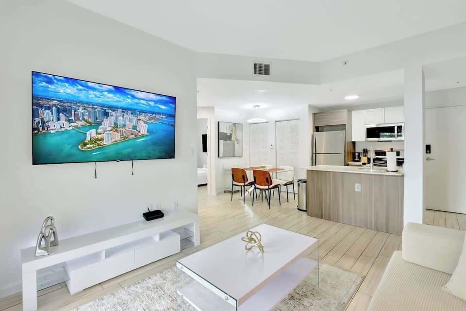 Spacious living room with cozy seating and a 65" smart TV, perfect for movie nights or relaxing after a day out.