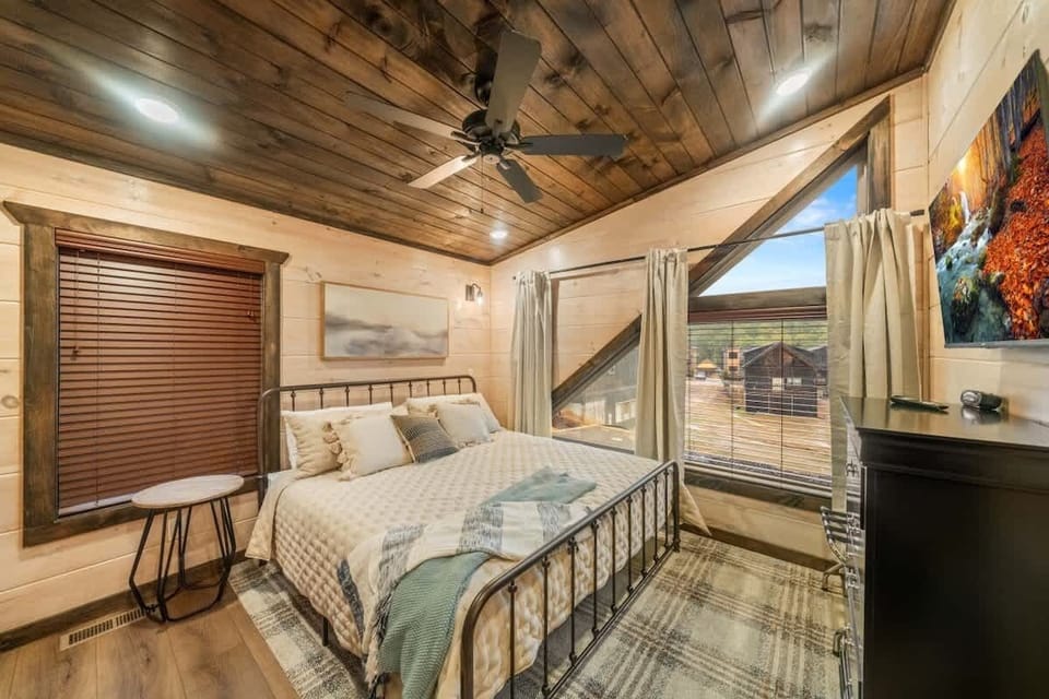 Third king suite located on the upper level with a dresser, ceiling fan, smart TV, and an ensuite full bathroom. 
