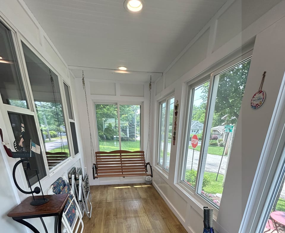 Sunroom with porch swing overlooks corner of Peach and 5th Ave