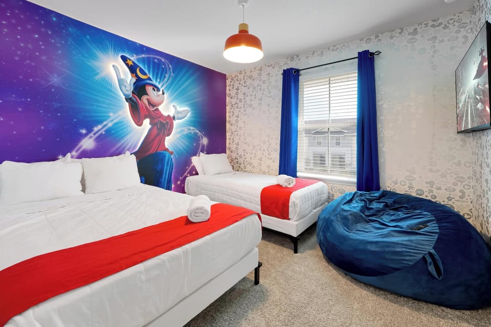 Bedroom 2: Whimsical bedroom with Mickey themed mural, twin beds, and cozy bean bag chair.