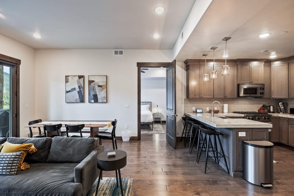 - Open concept layout connects dining and kitchen areas  
- Granite island with bar stools perfect for meals or drinks  
- Modern lighting and wood accents create a warm gathering space