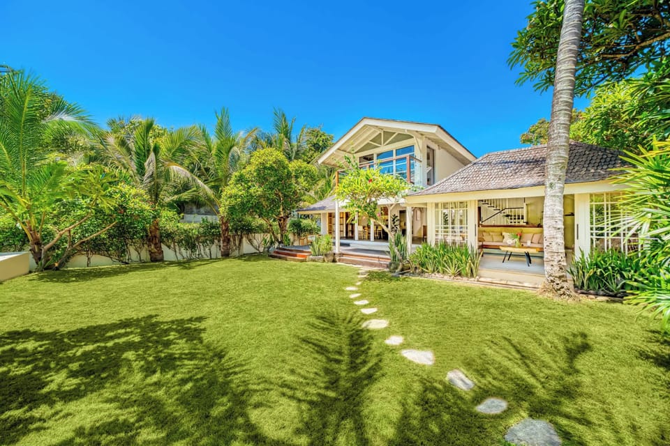 Spacious garden framed by tropical palms and soft sunlight