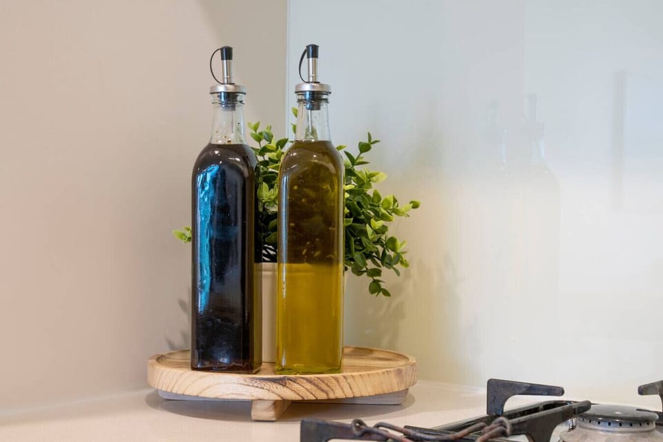 Stylish kitchen detail featuring oil and vinegar bottles on a wooden tray, paired with fresh greenery for a warm and inviting touch.
