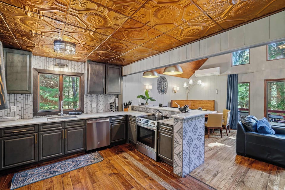 Take a wide look at the kitchen — full range, marble counter, geometric tile backsplash, and a layout that actually fits a group cooking together.
