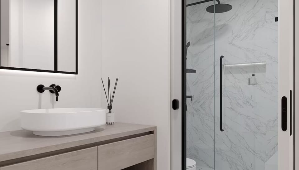 Refresh under a sleek rainfall shower in marble serenity.
