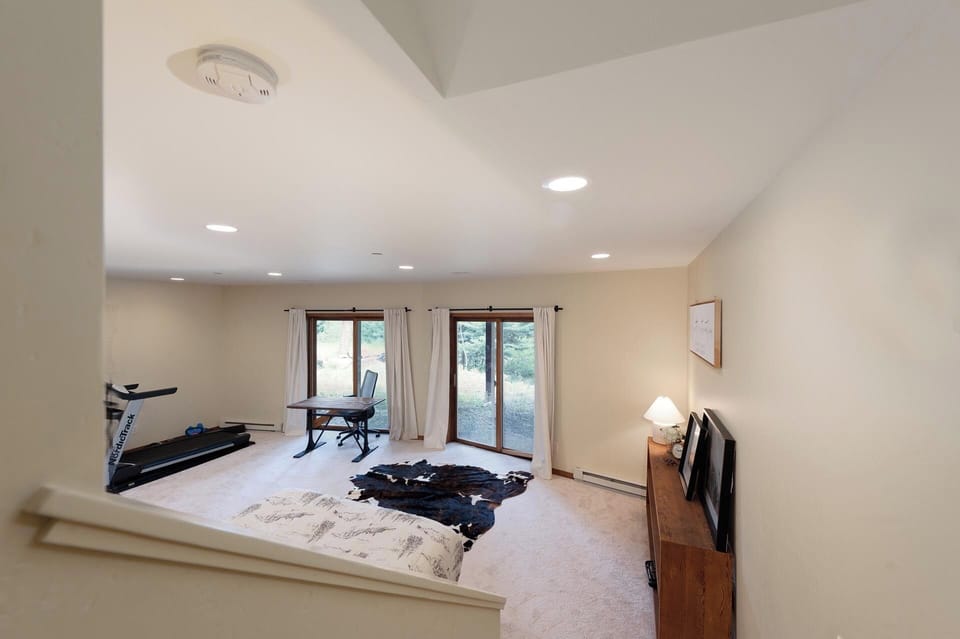 4th Bedroom & 2nd Living Space (Basement) - Queen Bed and Seating Area, Projection TV and Patio access (and even a treadmill)