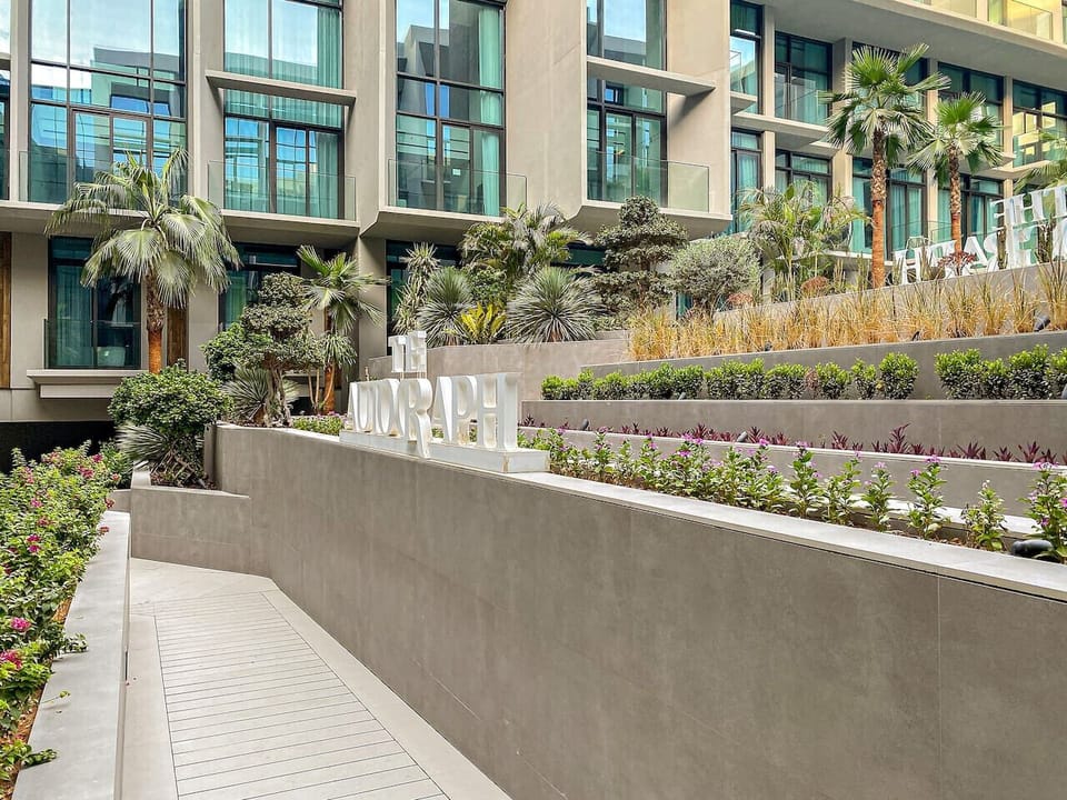 Garden Oasis: Stroll through lush greenery and modern elegance at The Autograph’s inviting entrance!
