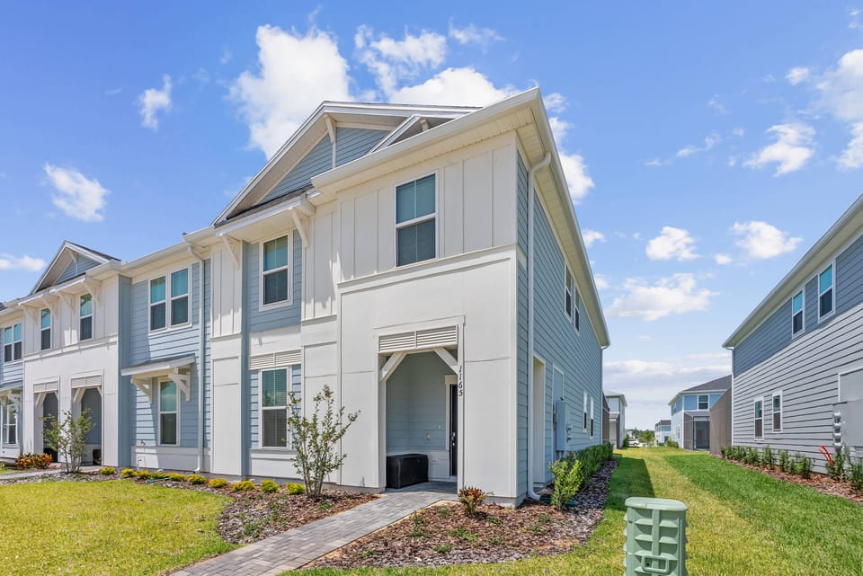 Discover a charming exterior with crisp white siding and lush landscaping that welcomes you in. Relax on the spacious porch while enjoying the clear blue sky and fresh air in this stylish home, perfect for your getaway.