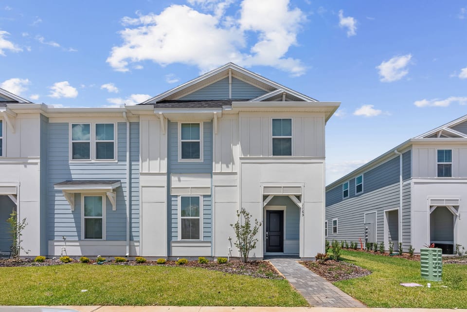 Discover the charm of this beautifully designed exterior with soft blue accents that create a welcoming atmosphere. The landscaped yard and tidy pathway invite you to explore the stylish interior just beyond the front door.