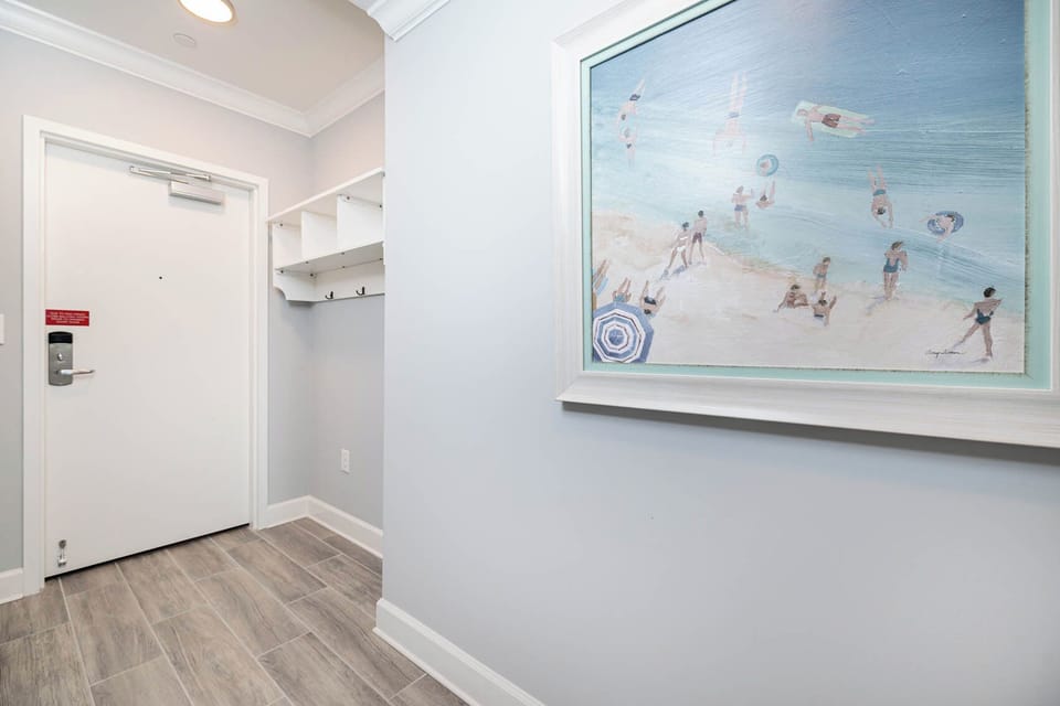 Inviting entryway with a coat rack and charming beach-themed artwork, perfect start to your beach getaway