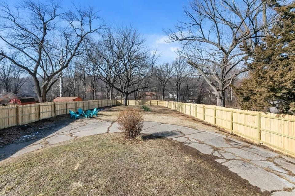 The grassy area is enclosed by a wooden fence, providing privacy and a sense of seclusion.