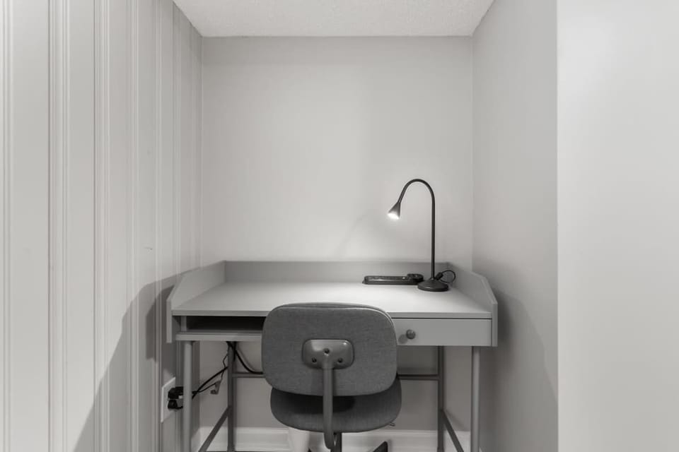 This bright and airy office space is perfect for working or studying. The desk features plenty of space for your laptop and other essentials. A comfortable chair and a desk lamp provide a comfortable workspace.
