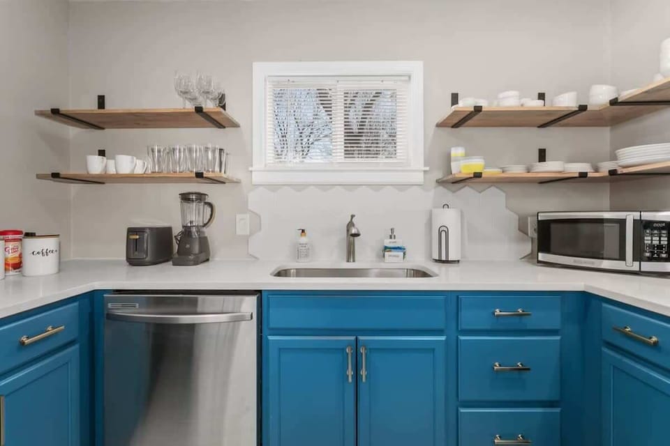Bright and airy kitchen with modern white cabinets and sleek stainless steel appliances. 