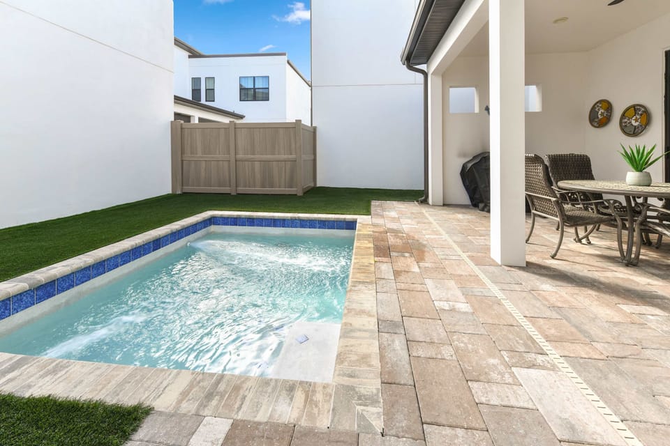 Covered patio with seating area next to a small private pool
