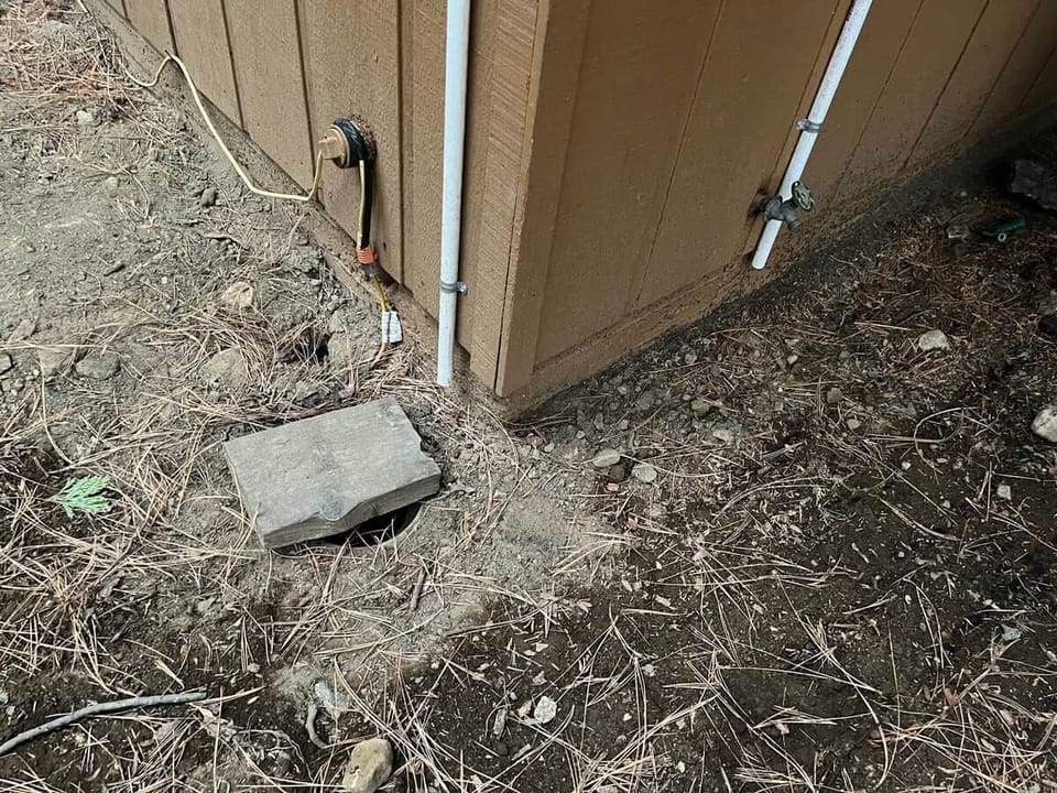 WINTER ONLY: Use the water supply valve under the wood hatch to turn the water off or on. The drain valve is to the right on the front wall of the cabin. Both are located on the left corner of the home as viewed from the street.
