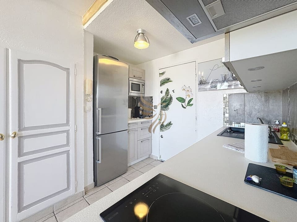 Cuisine éuipée, avec micro-ondes, réfrigérateur, congélateur et rangements.