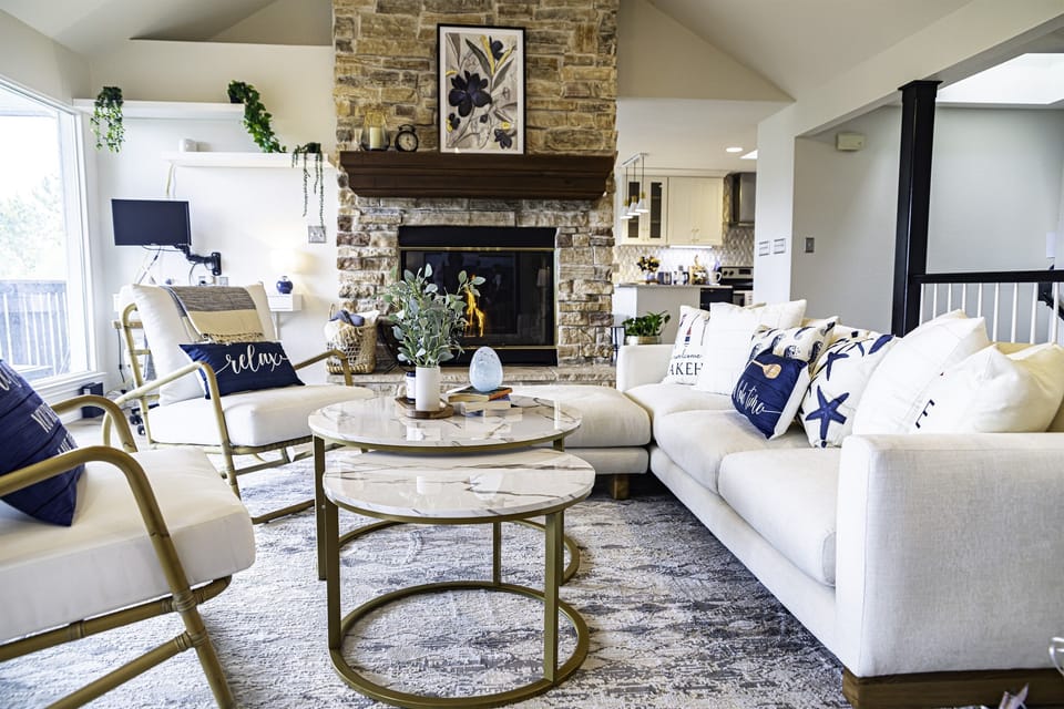 At the heart of the room, a stone fireplace stands as a focal point, its crackling flames casting a warm, inviting glow on chilly evenings. 