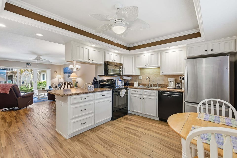 Fully equipped kitchen with modern appliances, breakfast bar, and open dining area. Perfect for your beach stay, this bright space connects to the living room—ideal for cooking, gathering, and relaxing after a day by the ocean.