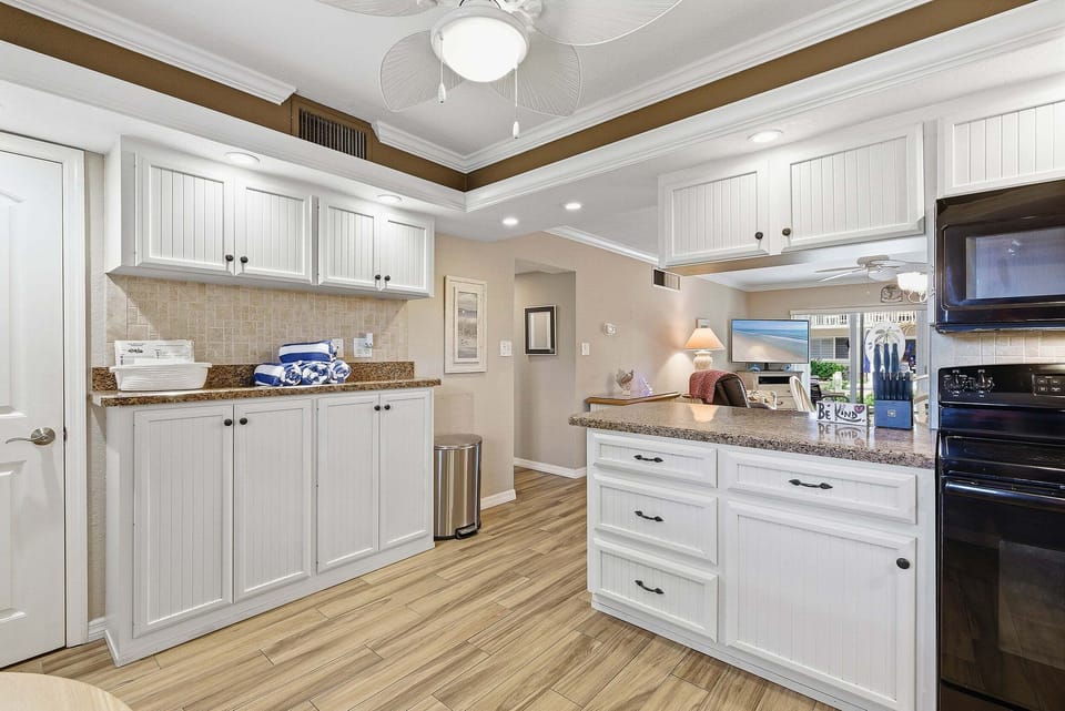 Bright, open kitchen with ample storage, modern appliances, and breakfast bar. Perfect for your beach stay, enjoy easy meal prep and seamless flow into the living area after a relaxing day by the ocean.