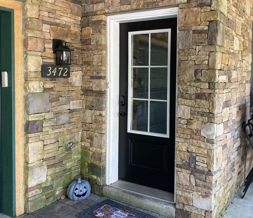 Welcoming private entry with elegant stonework and glass-paneled door