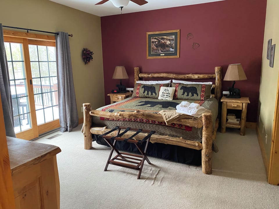 Cozy rustic king bedroom with private deck access and warm cabin charm