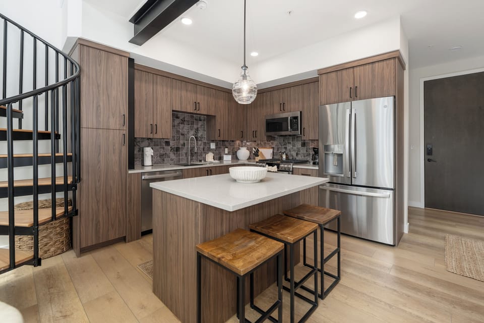 Your modern kitchen features sleek cabinetry, stainless steel appliances, and a stylish island perfect for morning coffee or evening conversations.