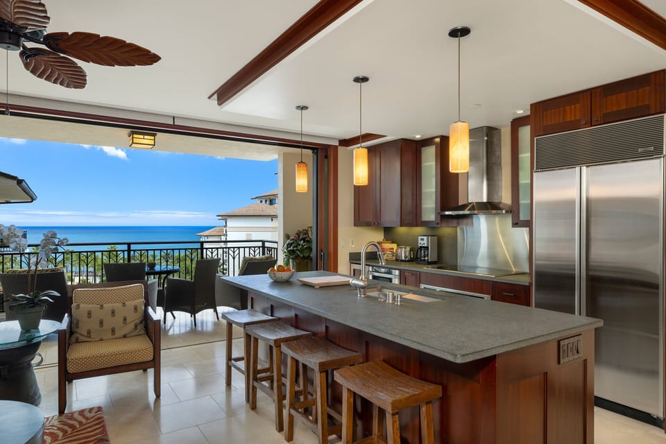 Chef’s kitchen captures blue-water vistas through wide sliding doors.
