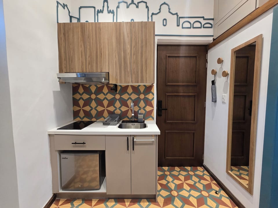 Kitchen with a two-burner electric stove and a mini fridge.