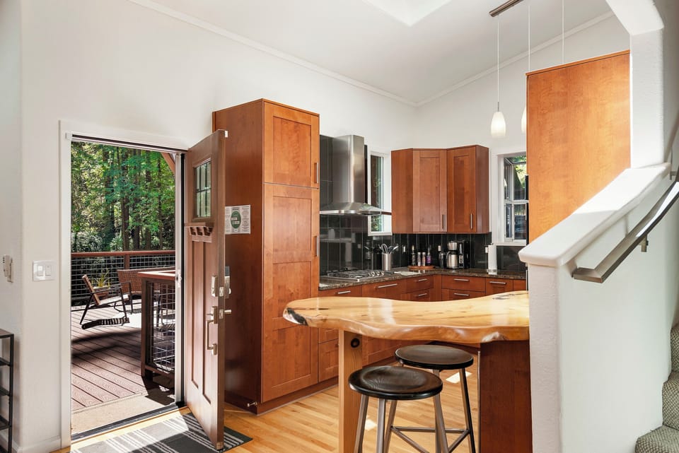 Just inside the front door, a custom redwood slab bar with embedded details (don't forget too look when you get there!) leads into the kitchen.