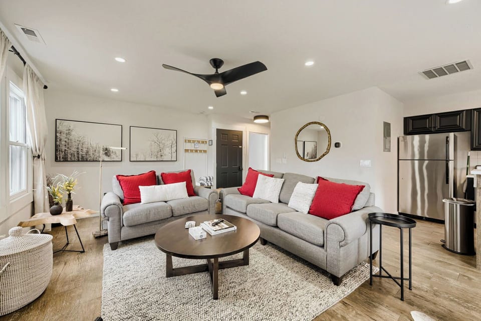 Settle into this bright, modern living space with plush seating and vibrant red accents that invite you to unwind after your adventures.