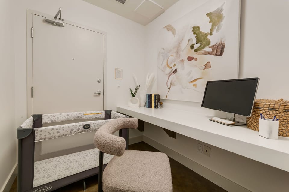 Bright workspace nook with comfortable seating and doubles as a completely blacked out nap room for babies.