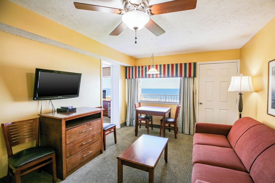 Relax in the bright living room with sleeper sofas and balcony access.