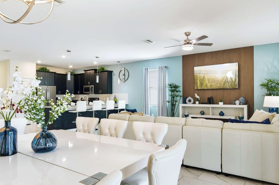 Open flow: elegant dining, spacious lounge, and dark modern kitchen.