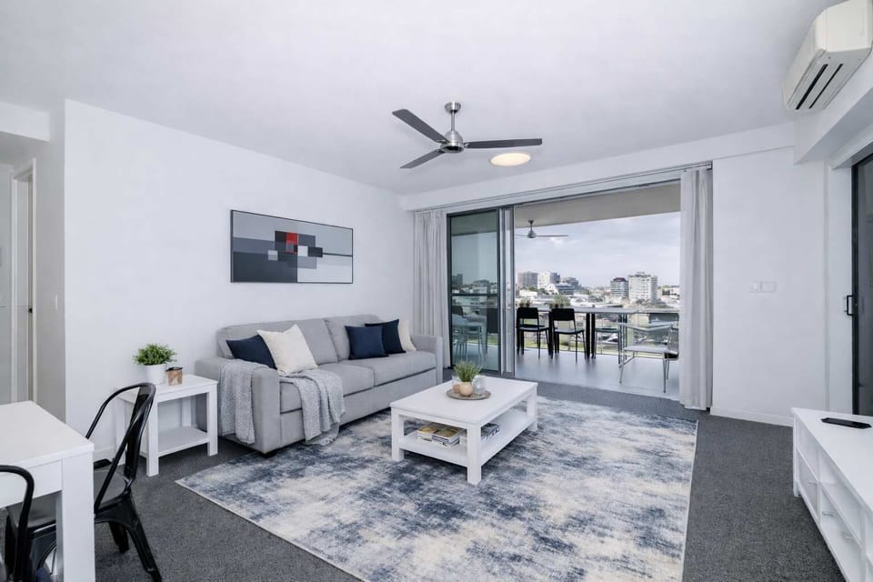 Spacious living room with sofa, TV and air conditioning