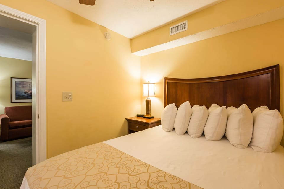 Rest easy in the cozy queen bed with warm lighting and soft linens.