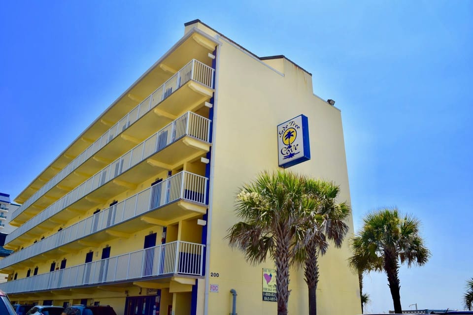 Colorful resort exterior framed by palm trees and ocean breezes.