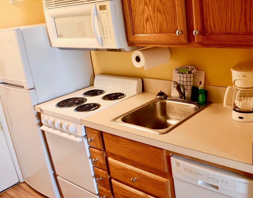 Full kitchen setup with stove, oven, microwave, and fridge.