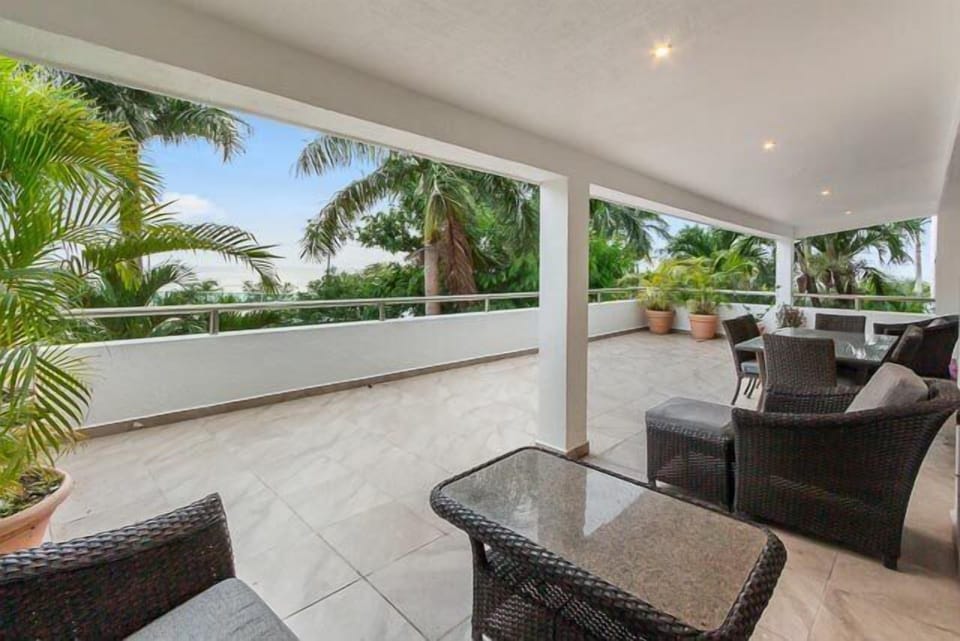 Patio seating with armchairs and small dining table, a cozy spot to soak in the Caribbean ambiance.
