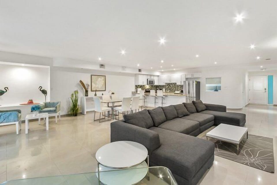 The large living room has an l shaped couch and several seating areas.