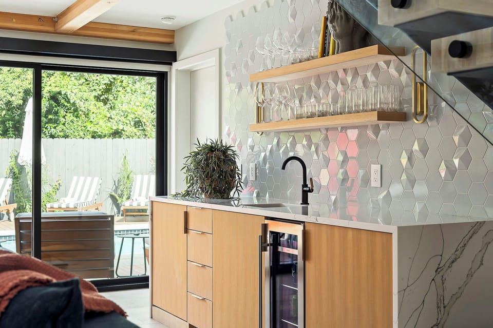 An alternate angle of the wet bar area showing its proximity to the patio, highlighting natural light and clean architectural lines.