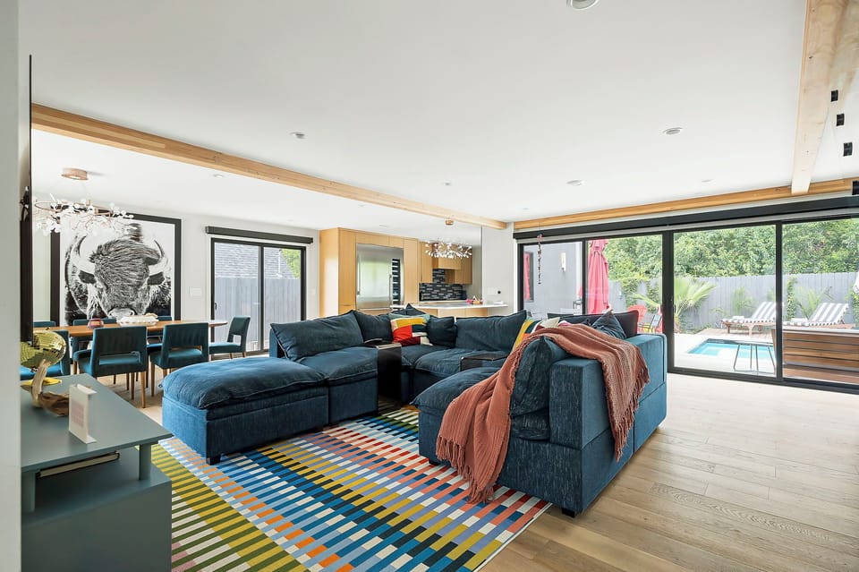 A bright and inviting space with ample seating, modern decor, and direct access to the outdoor patio through sliding doors.
