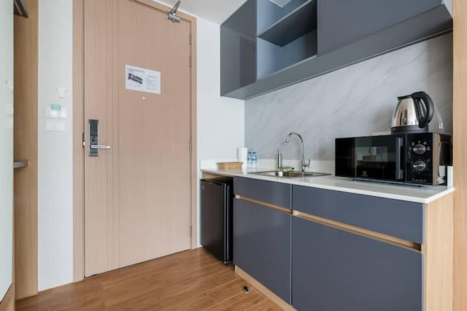 Modern kitchenette equipped with microwave, kettle, and essential appliances.