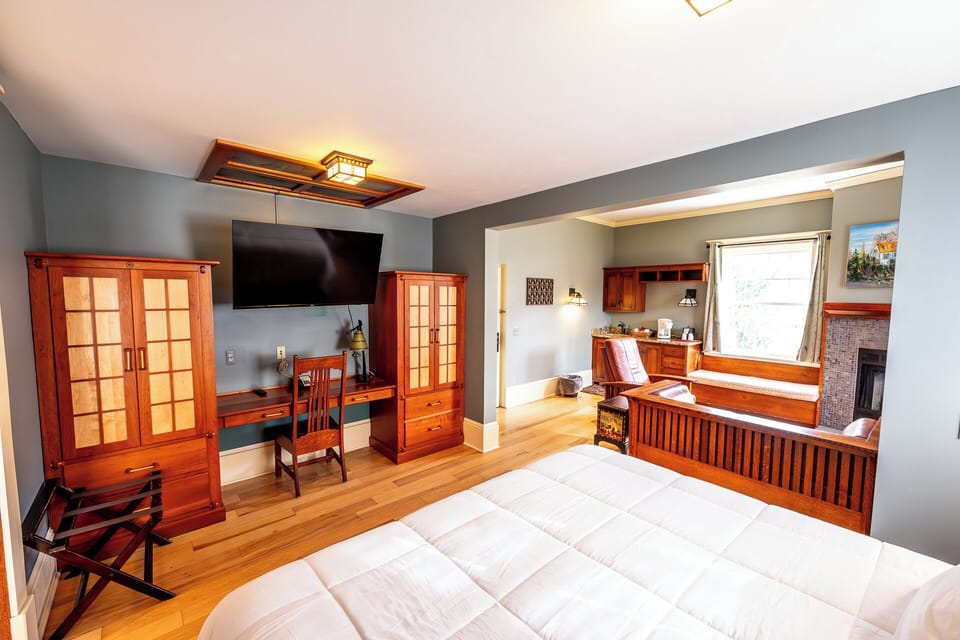 Unwind in a spacious suite bedroom with warm wood accents.