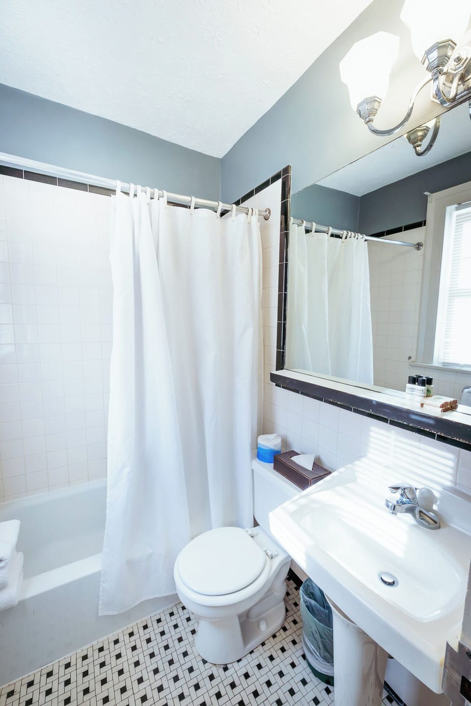 Freshen up with bright lighting and a classic tiled bath.