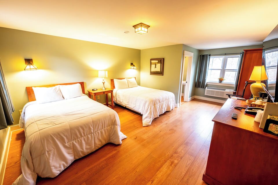 Step into airy comfort with two beds and warm lighting.