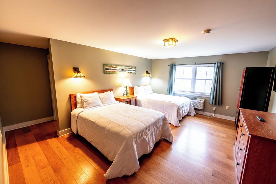 Unwind in bright comfort with two plush beds and sunlight.