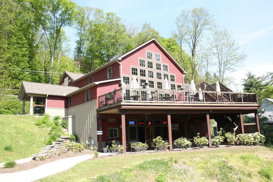 Arrive to a charming lodge exterior wrapped by green hills.