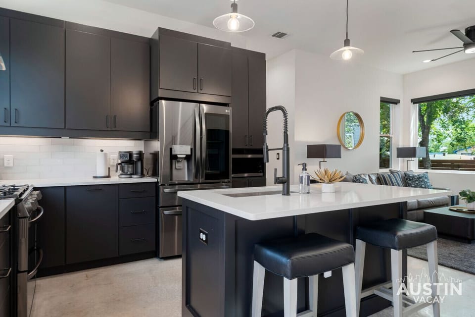 Dark cabinets, bright vibes. Coffee, cooking, and couch time all in one sleek sweep.